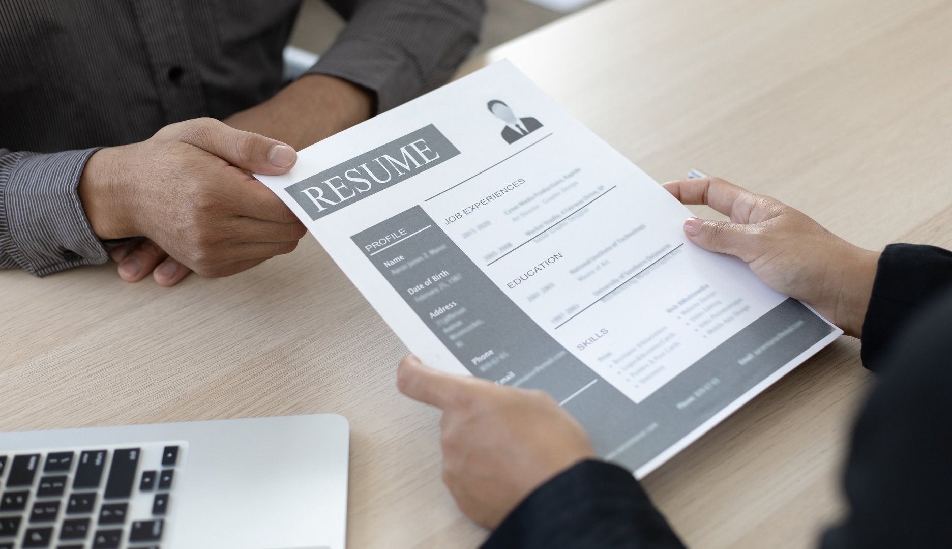 Employer Checking Applicant's Resume During Interview